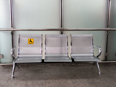 位于火车站的不锈钢椅, 配有残疾告示牌, 方便残疾人士使用列车服务。