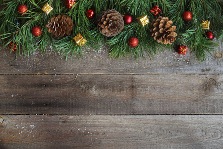 圣诞贺卡上木制背景与雪杉树 松树球果和装饰的小玩意。查看与副本空间