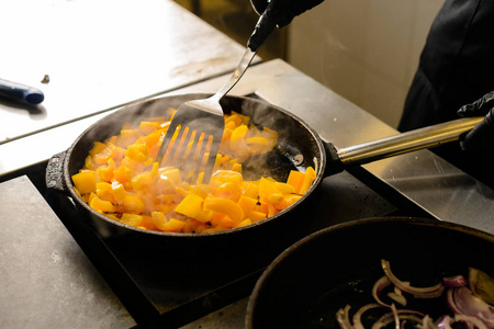 厨师把产品混合在一个煎锅里, 在餐厅里做饭的过程中