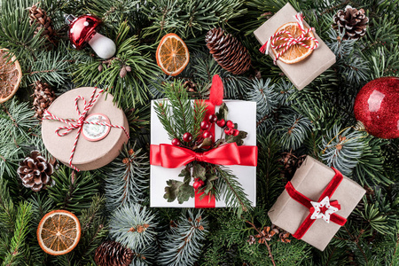 圣诞礼品盒与红色装饰, 松果在树枝背景。圣诞节主题, 自然新年概念。平面布局, 顶部视图
