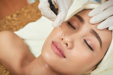 亚洲妇女在接受治疗面部皮肤治疗时休息治疗表