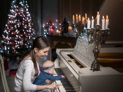 妈妈带着一个孩子靠近一架白色的钢琴