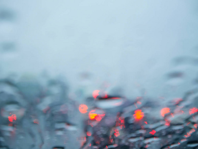 模糊的雨在汽车挡风玻璃或挡风玻璃与散景光背景从交通