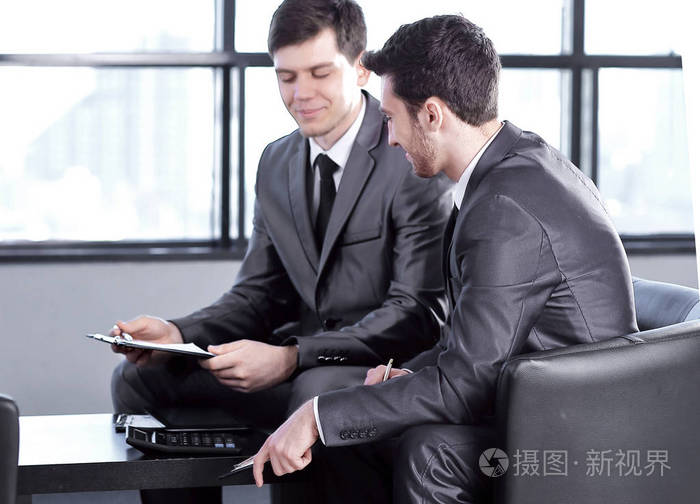 老板用剪贴板坐在办公室里带有复制空间的照片