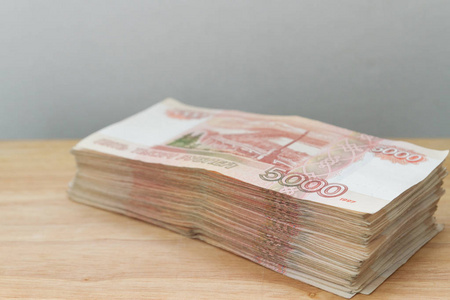 一大堆俄罗斯5000卢布躺在一张木桌上