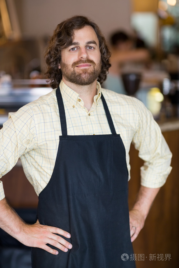 两手叉腰站在自助餐厅里的男主人