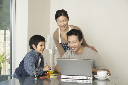 家长电脑父亲在饭厅里的电脑上工作照片