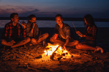 年轻的朋友在海滩上野餐和篝火