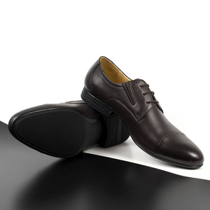 古典对棕色男性鞋子被隔绝在白色和黑色背景与阴影