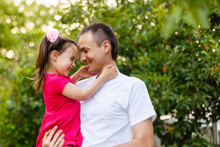 快乐的年轻父亲与他的小女儿在果园花园乐趣