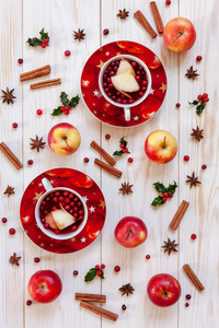 热圣诞水果饮料与香料和浆果与冬青, 红苹果, 肉桂, 茴香和蔓越莓在木背景的顶部视图
