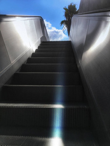 自动扶梯楼梯通向明亮的天空。成功的概念