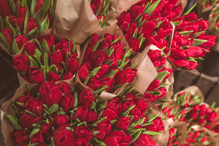 春季市场上的红郁金香花在棕色纸袋里
