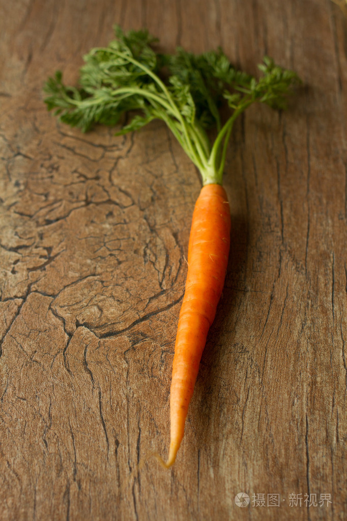 美味有机胡萝卜放在了一个棕色的背景
