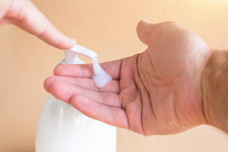 液体肥皂瓶和压在饮水机上, 肥皂在手掌上。洗手