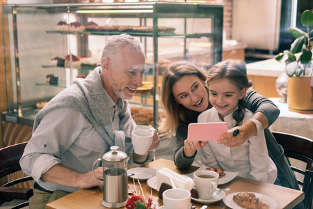 外婆拿着她的粉色智能手机向孙女展示照片