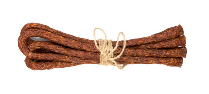 在白色背景上被隔离的绳子绑着细长的烟熏香肠。传统波兰卡巴诺西或弗里斯兰干香肠棒