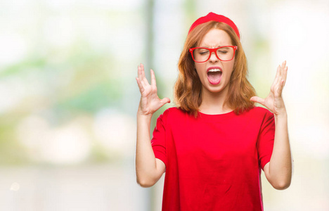 年轻美丽的女人在孤立的背景下庆祝疯狂和疯狂的成功与手臂举起和闭上眼睛尖叫兴奋。赢家理念