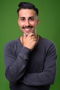 年轻英俊的伊朗男子与胡子对绿色背板