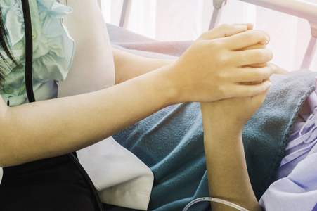 坐在生病孩子床上的女医生.用手牵手,概念,治疗和获得健康保险照片