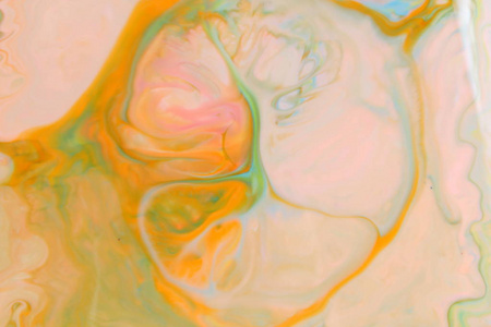流体艺术。抽象橙色绿色背景在液体。多彩多姿的油漆污渍。模糊模式