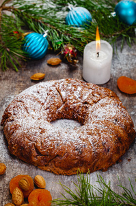 传统的圣诞蛋糕与干果, 葡萄干和坚果与木制背景的圣诞装饰。特写
