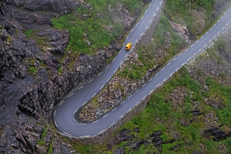 公路上的黄色汽车在山上的高速公路上循环