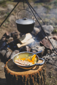 在火上做饭。火上的鱼汤。火上大锅里的食物。户外食物。在户外烹饪。在大锅上烹饪大自然