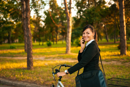 健康的生活方式理念。女商人骑自行车在公园里