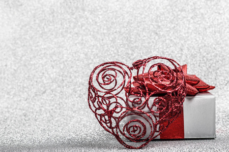 节日装饰的圣诞节日作文心形球和礼品盒银色闪光散景背景