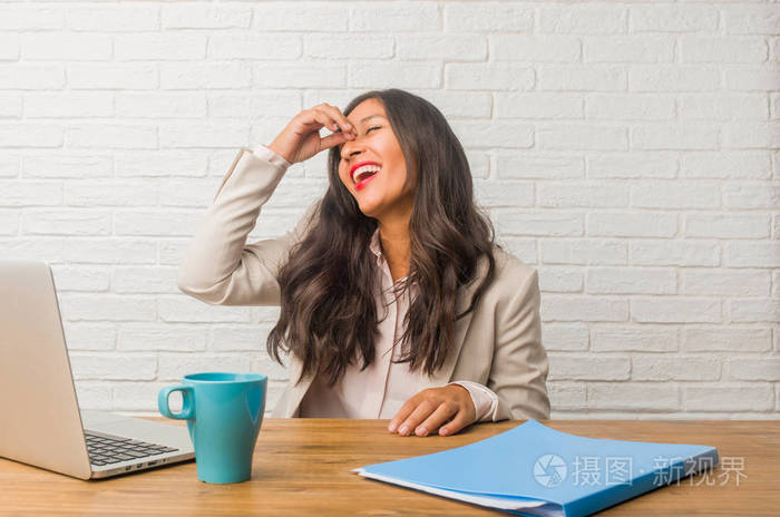 年轻的印度妇女在办公室笑和有乐趣照片-正版商用图片0au5cu-摄图新