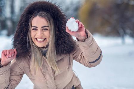 冬天时间微笑的女孩在冬天雪天玩雪球战斗