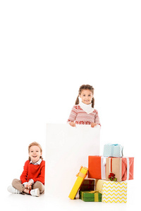 可爱的小孩子堆圣诞礼物和空白板上孤立的白色