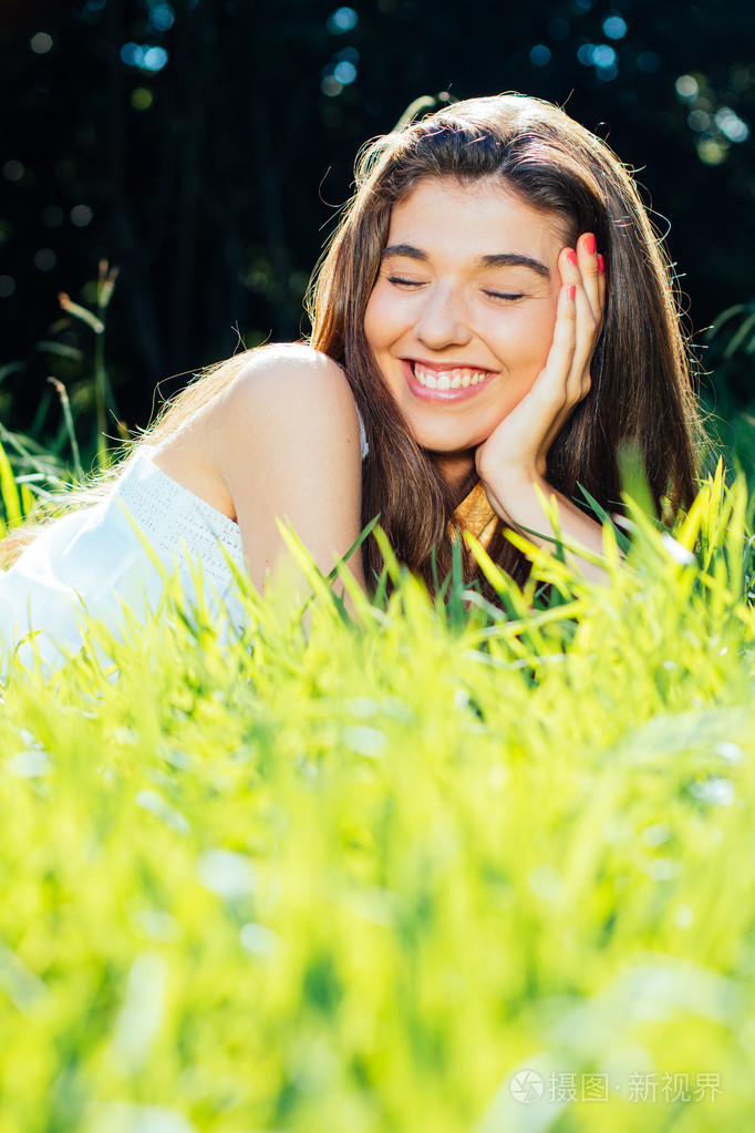 幸福的女人躺在草地上