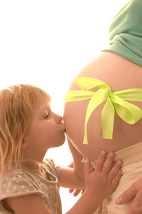 怀孕妇女抱着婴儿在白色背景上