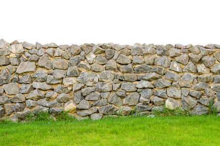 篱笆真正石墙壁表面水泥在绿色的草田