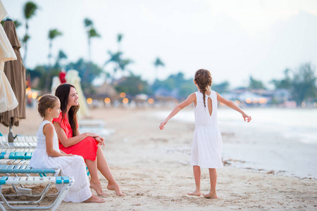 美丽的母亲和她可爱的小女儿在海滩上