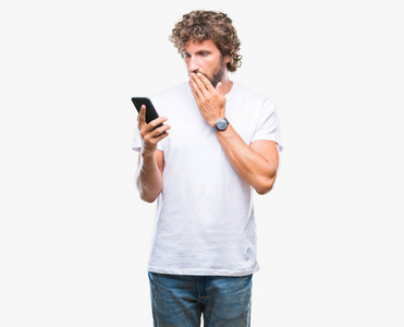 英俊的拉美裔人模型发送短信短信使用智能手机在孤立的背景盖嘴用手震惊的错误, 表达恐惧, 在沉默中害怕, 秘密概念