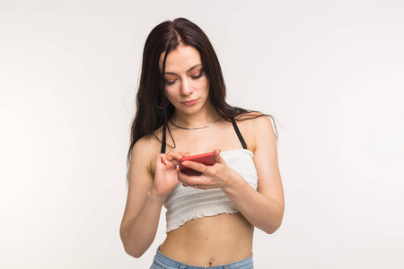 技术和人概念年轻妇女看一些东西在她的手机在白色背景