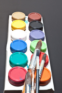 刷子和彩色的绘画艺术家在灰色的背景上