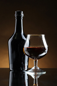 白兰地和棕色背景上的瓶玻璃