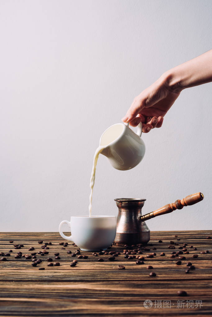女人把牛奶倒在乡间的木桌上喝咖啡的镜头
