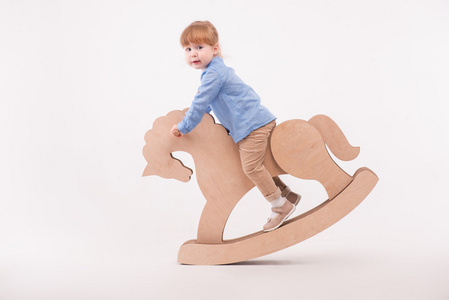 儿童与玩具马儿童马术棚拍中国新年唐装儿童拿糖葫芦骑小马骑马的孩子