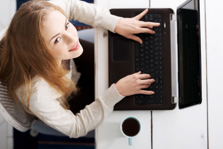 年轻女子在家里使用便携式计算机