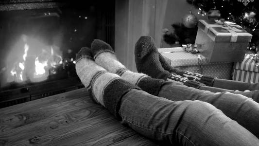 黑色和白色的家庭在圣诞前夕的壁炉放松的形象