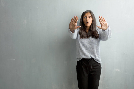 年轻的印度女人反对垃圾墙把手在前面, 停止手势