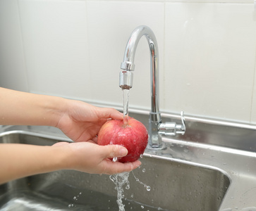 女人手洗苹果照片