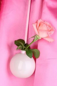 美丽布背景上挂着的花瓶里的玫瑰