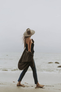 在海滩上赤脚行走的女人