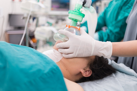 抱着氧气面罩的预氧下巴电梯位置医生在护士把氧气面罩放在病人身上时